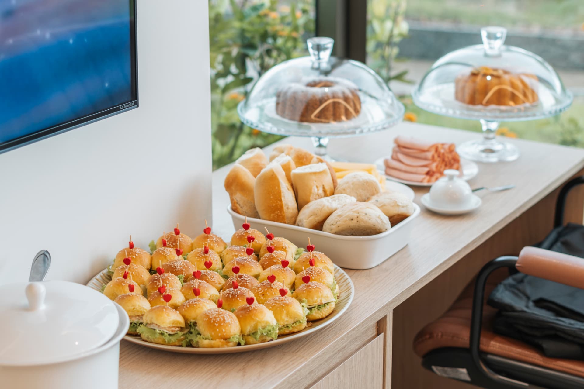 Mesa de receptivo com pães, frios e mini salgados