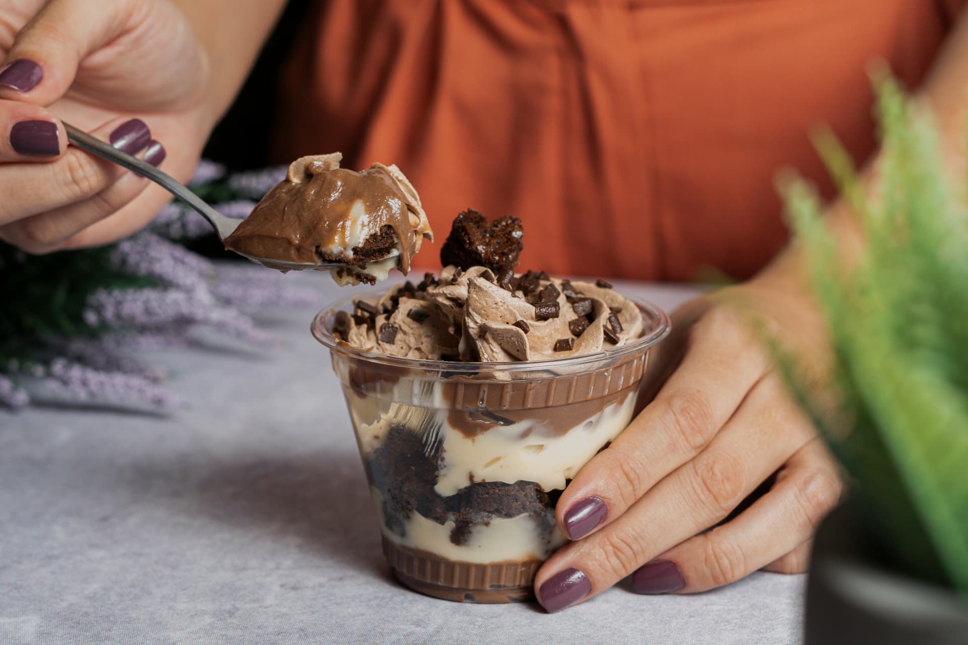 Copo de sobremesa com camadas de brownie, creme e raspas de chocolate